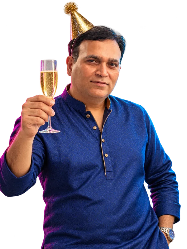 Nirbhay Singh in a blue kurta and gold party hat raising a champagne toast